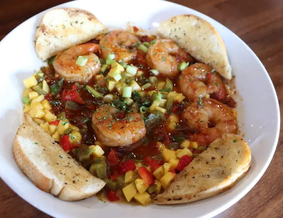 Stage Stop menu features Seafood Santa Fe with jumbo shrimp atop pasta and vegetables with four slices of garlic toast along the edges of the plate