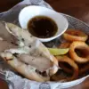 French Dip hoagie style sandwich served with au jus and onion rings
