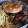 Deluxe Burger is loaded with bacon and served with seasoned french fries