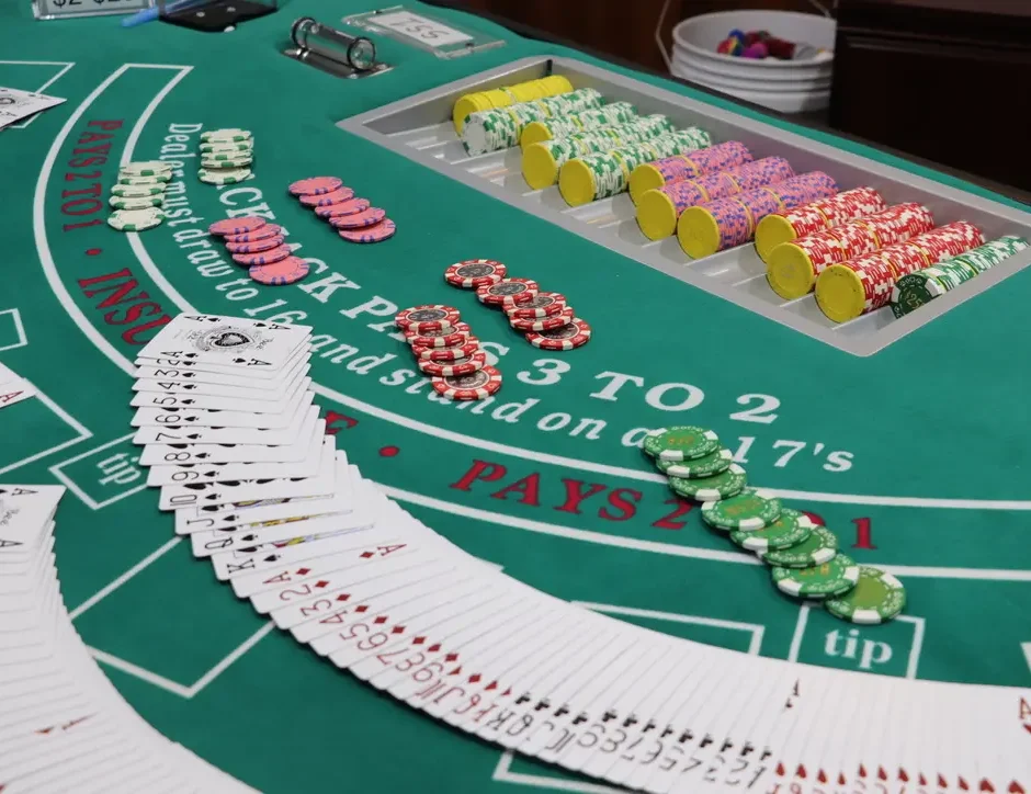 Blackjack table with playing cards spread across and poker chips laid out