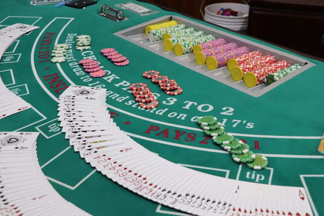 Blackjack table with playing cards spread across and poker chips laid out