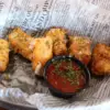 Queso Cheese Curds in a basket with marinara sauce