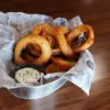 Basket of onion rings with sauce