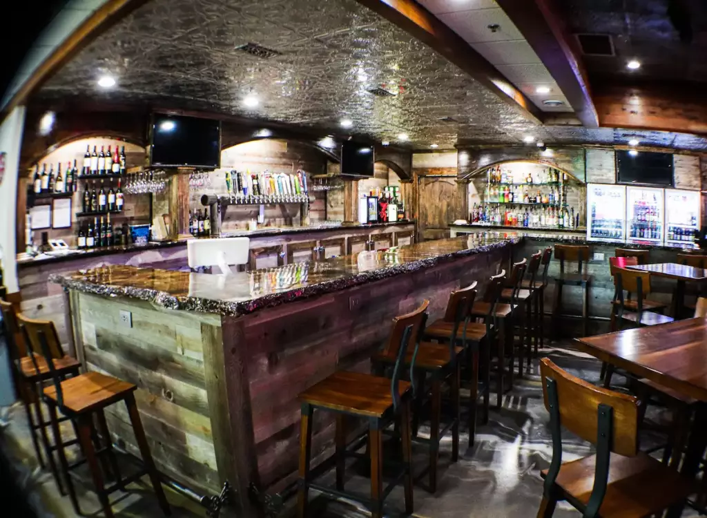 Main bar area on the main level of Stage Stop with a long bar counter and wine, beer taps and liquor behind the counter