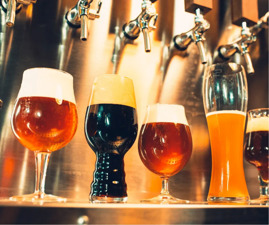 Variety of beer glasses under taps