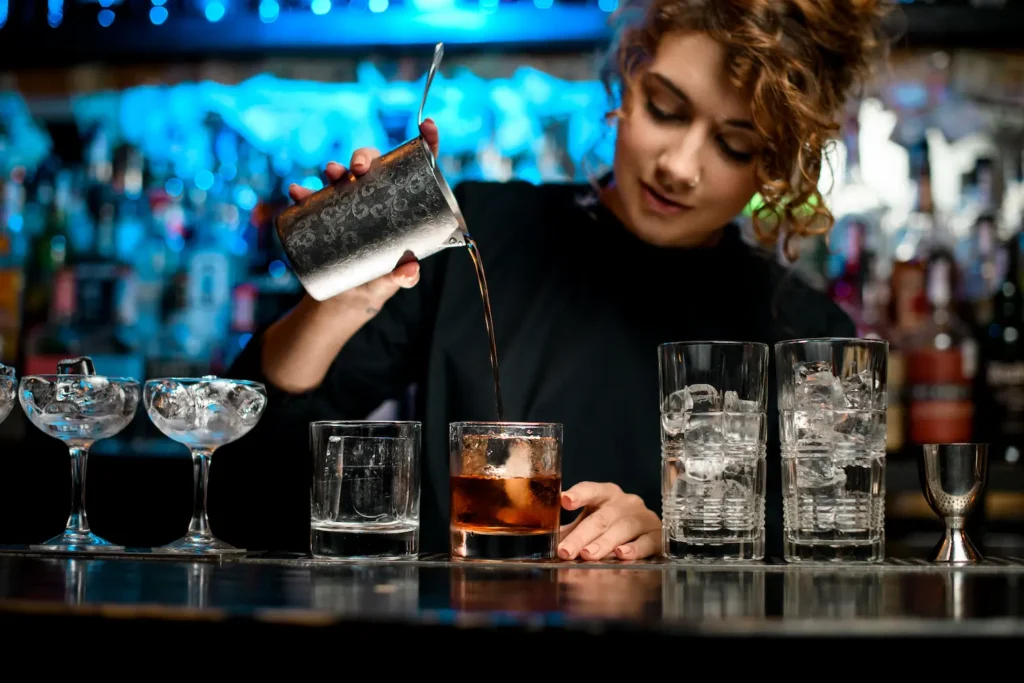 Female bartender pouring a cocktail