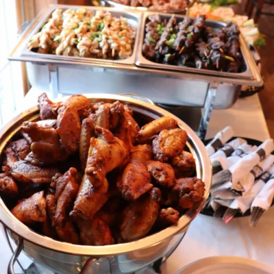 Catering table with chicken wings, chicken skewers and steak skewers