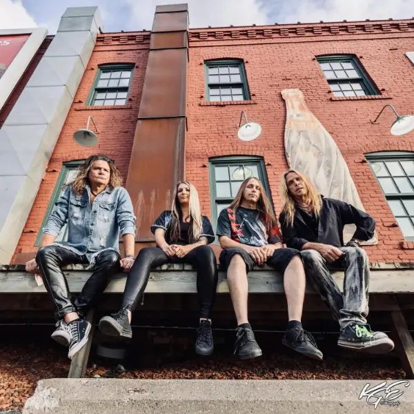 Four Frantic Anarchy band members sitting on a ledge. Three are male, and one is female.