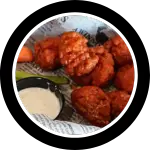 Basket of boneless breaded buffalo wings with dipping sauce