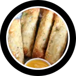 Basket of fried Philly Cheesesteak egg rolls with cheese sauce for dipping