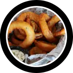 Basket of large crispy onion rings with dipping sauce